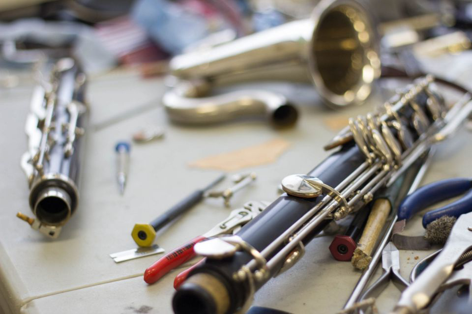 A picture of a clarinet and trombone being repaired.